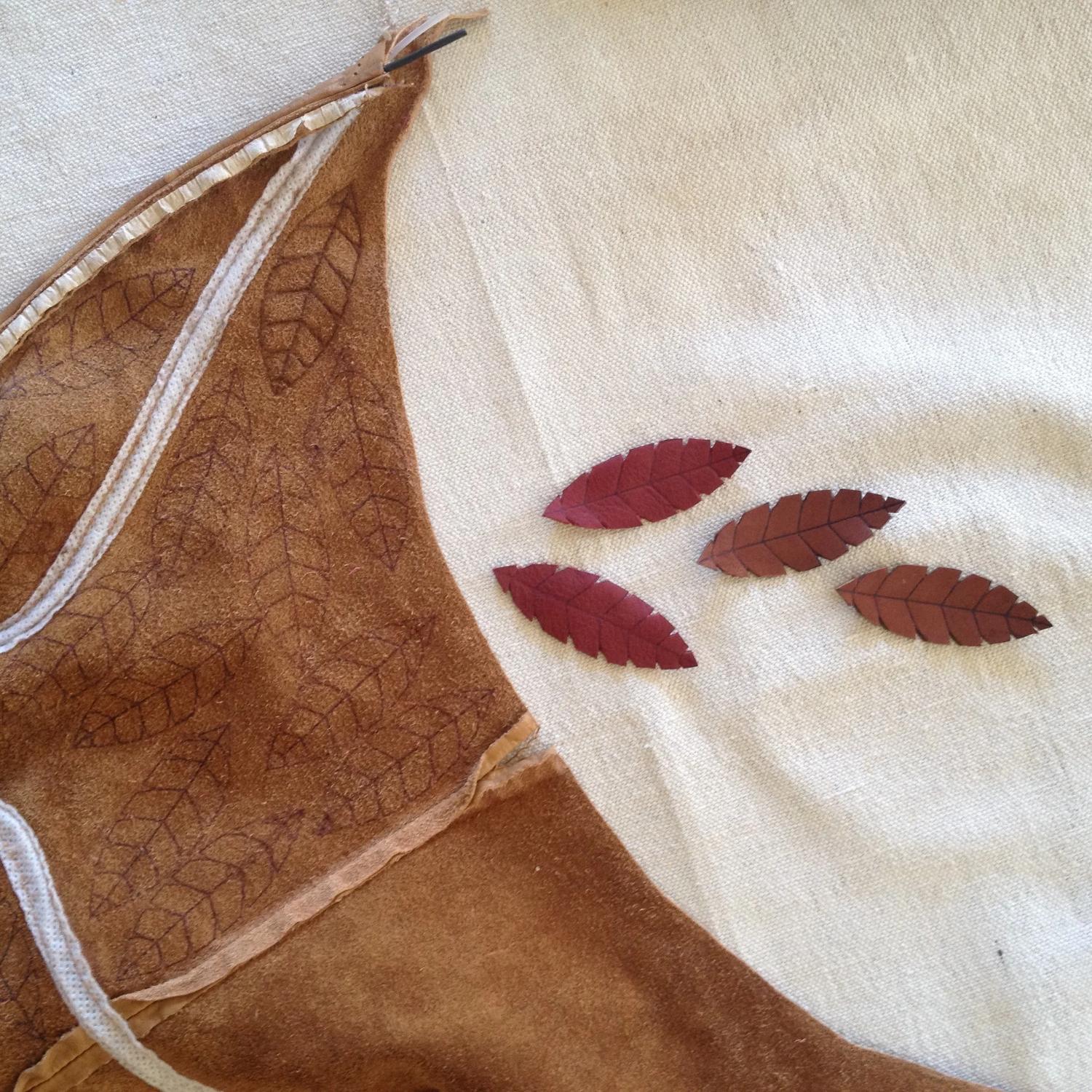 Tooled brown leather and small cut leaves on linen