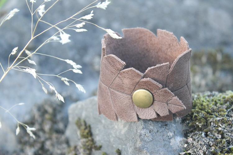 A feather-leaf leather cuff on a rock, with dried grass